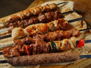 A variety of grilled meat skewers served on flatbread, showcasing delicious kebabs.