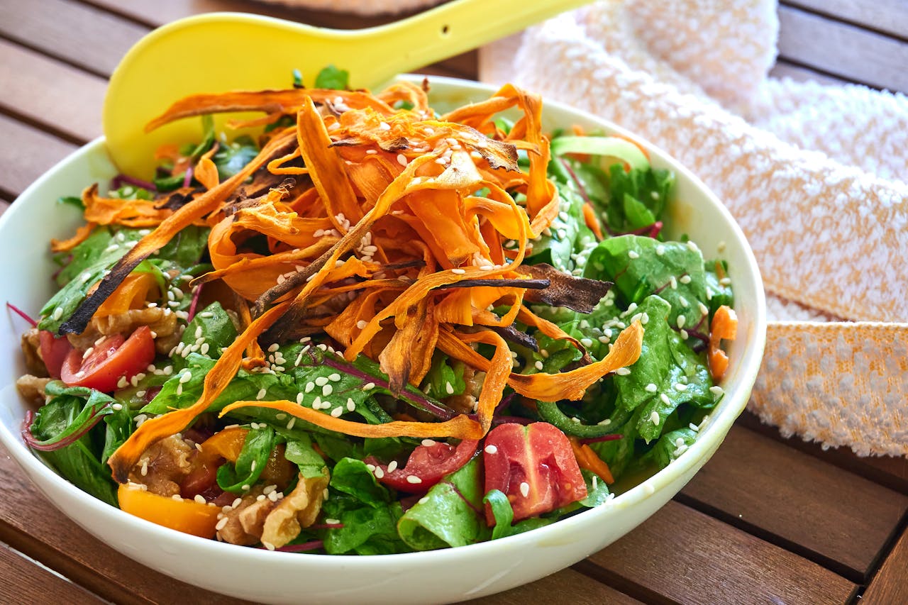 Vibrant vegetable salad topped with sesame seeds and roasted carrots, perfect for a healthy meal.